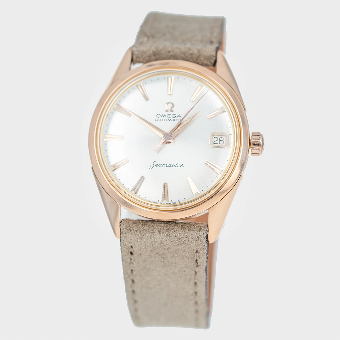 vintage rose gold omega Watch with gold case and beige strap on a light gray background