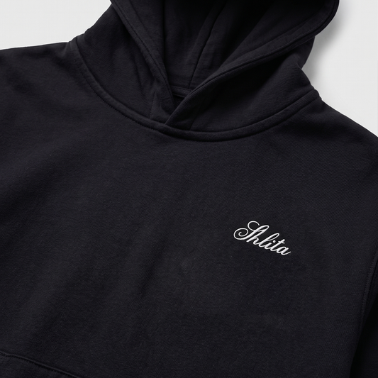 Black hoodie with 'Shlita' embroidery on a light gray background
