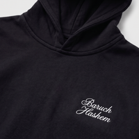 Black hoodie with 'Baruch Hashem' text on a white background