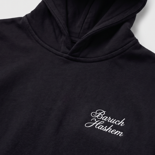 Black hoodie with 'Baruch Hashem' text on a white background