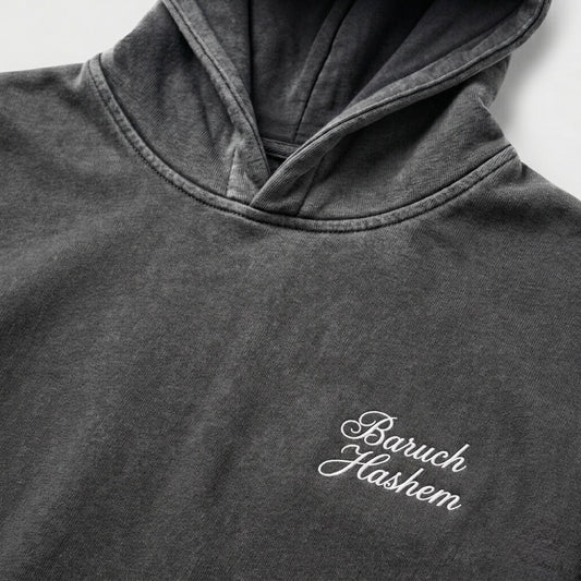 Vintage black hoodie with 'Baruch Hashem' embroidery on a light gray background