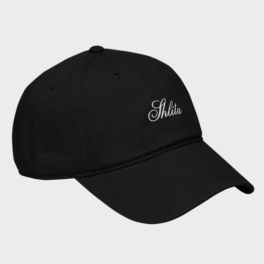 Black cap with 'Shlita' embroidery on a light gray background