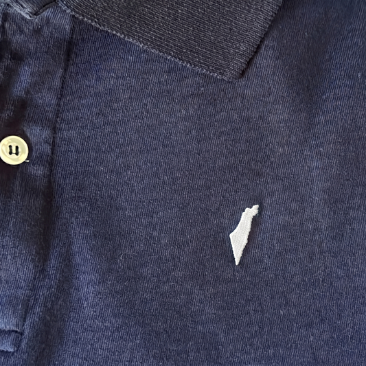 Close-up of a navy blue garment with a small white israel logo on the fabric.