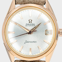Rose Gold Omega vintage Seamaster watch with a white face on a light background